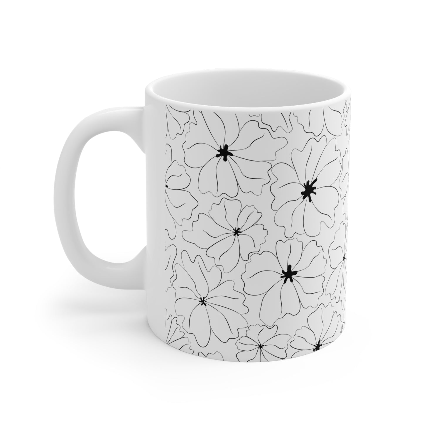 Side view of cup with handle to the left showing a pattern of black and white flowers