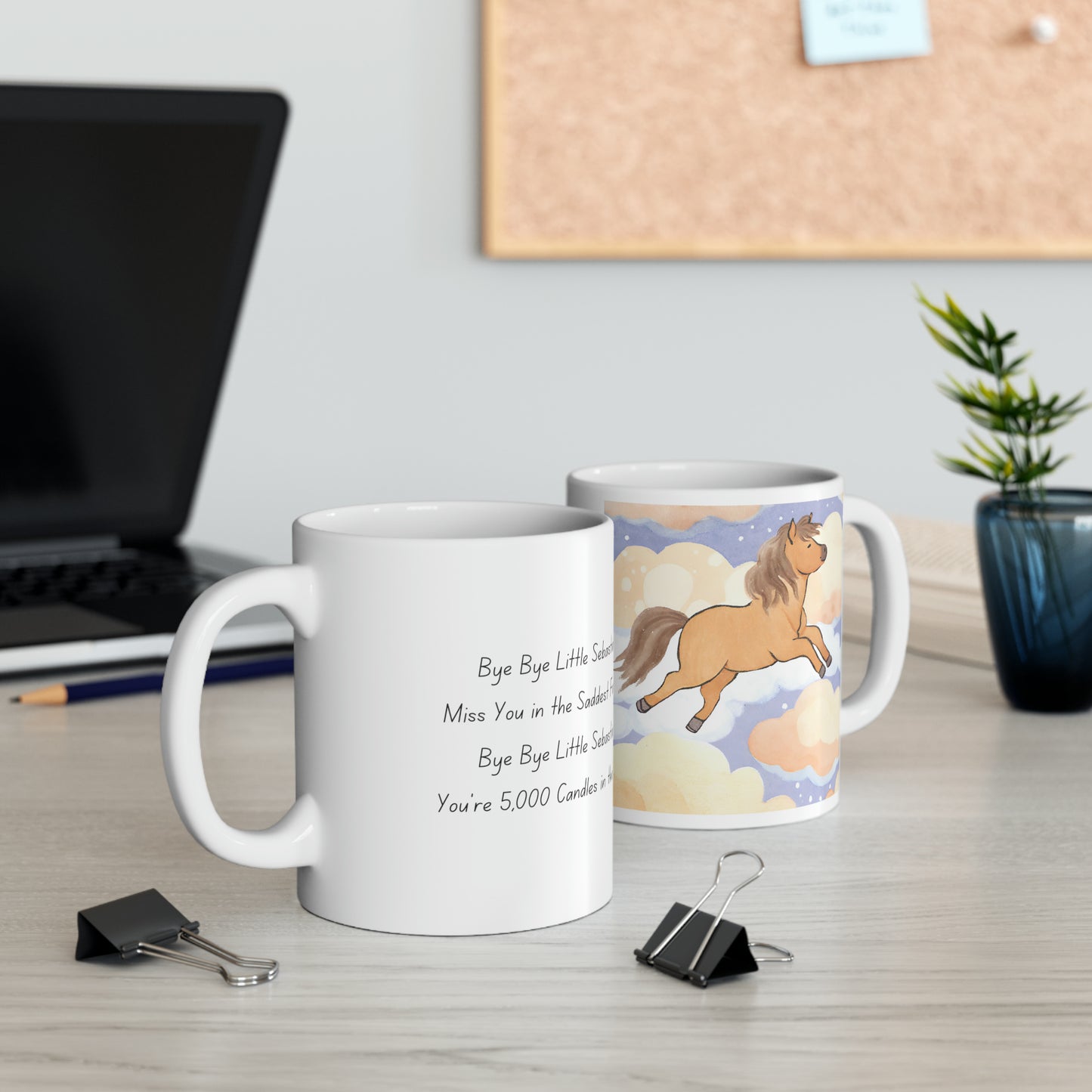 two coffee mugs sitting on a desk next to a laptop